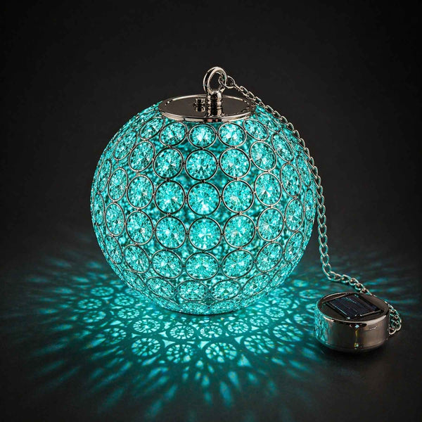 Turquoise crystal ball with solar light on a black background