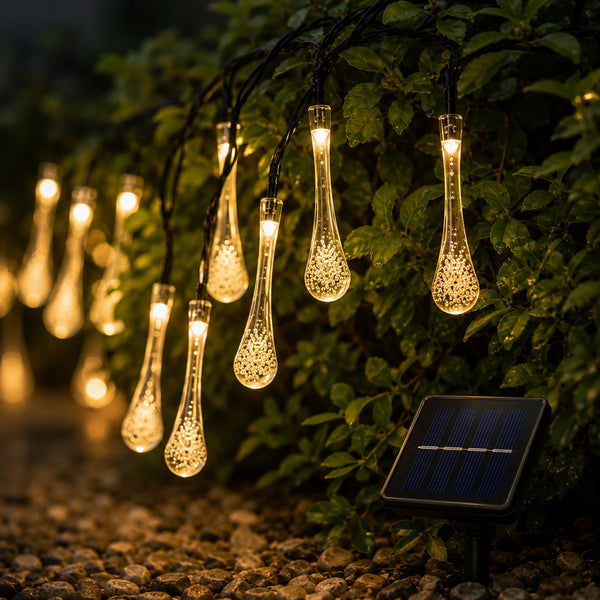 String of water droplet-shaped solar lights on a garden path with a solar panel.